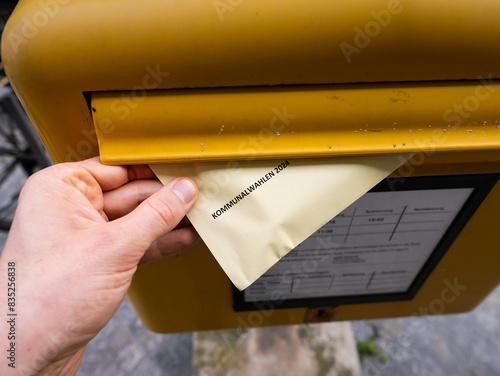 Postal voting for the Kommunalwahl 2024 (municipal election) in Saxony. Posting the envelope with the ballot paper into a postbox in Germany. Casting a ballot for the city council. photo