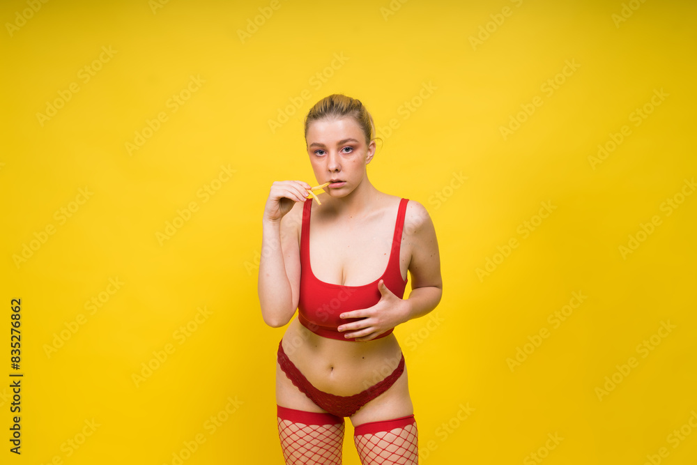 Young beautiful slender female eating french fries. Concept of un healthy fat junk and healthy food Young beautiful slender female eating french fries. Concept of un healthy fat junk and healthy food
