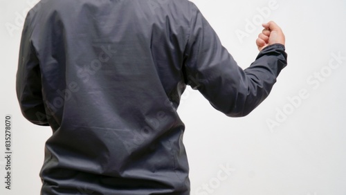 Obraz na plátně A man in a black jacket with his fist raised in the air.