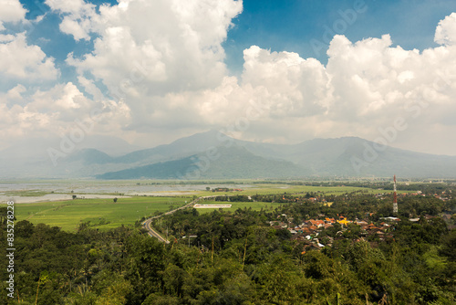 Vibrant Valley View with Green Fields and Mountains Under Cloudy Skies, A Picturesque Rural Landscape ; semarang indonesia tourism ; Rawa pening lake from above photo