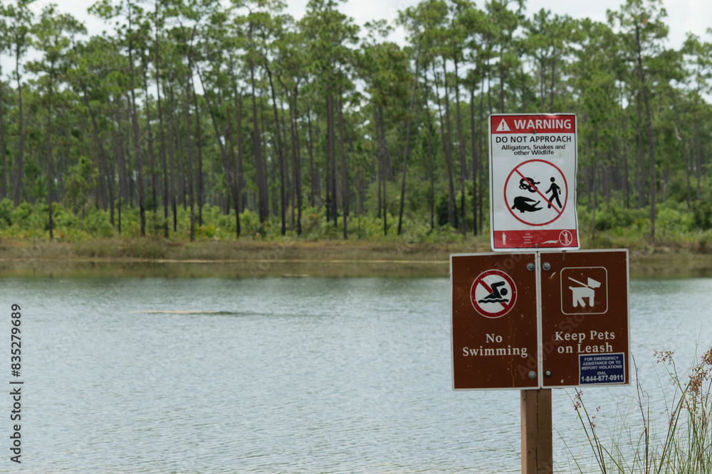 Warning signs by a lake in a forest