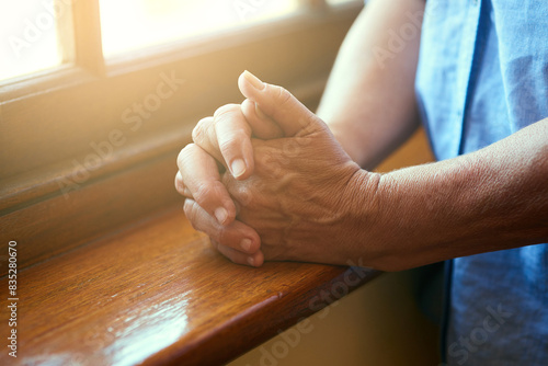 Hands together, anxiety or person with stress, fear and problem in home praying for hope. Closeup, senior or nervous gesture with grief, religion and worry in apartment, retirement or house by window