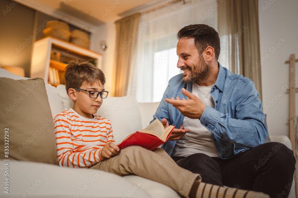 Father and son read a book and have fun while spend time together Father and son read a book and have fun while spend time together