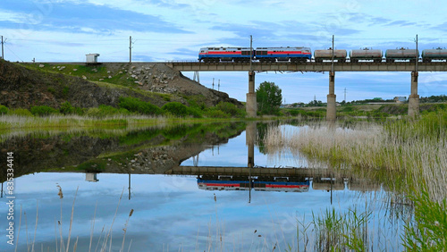 A train passing over a railway bridge over the Tobol River in Kazakhstan photo