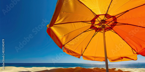 Orange Yellow Beach Umbrella  A large  colorful beach umbrella  providing shade from the sun on a sandy beach