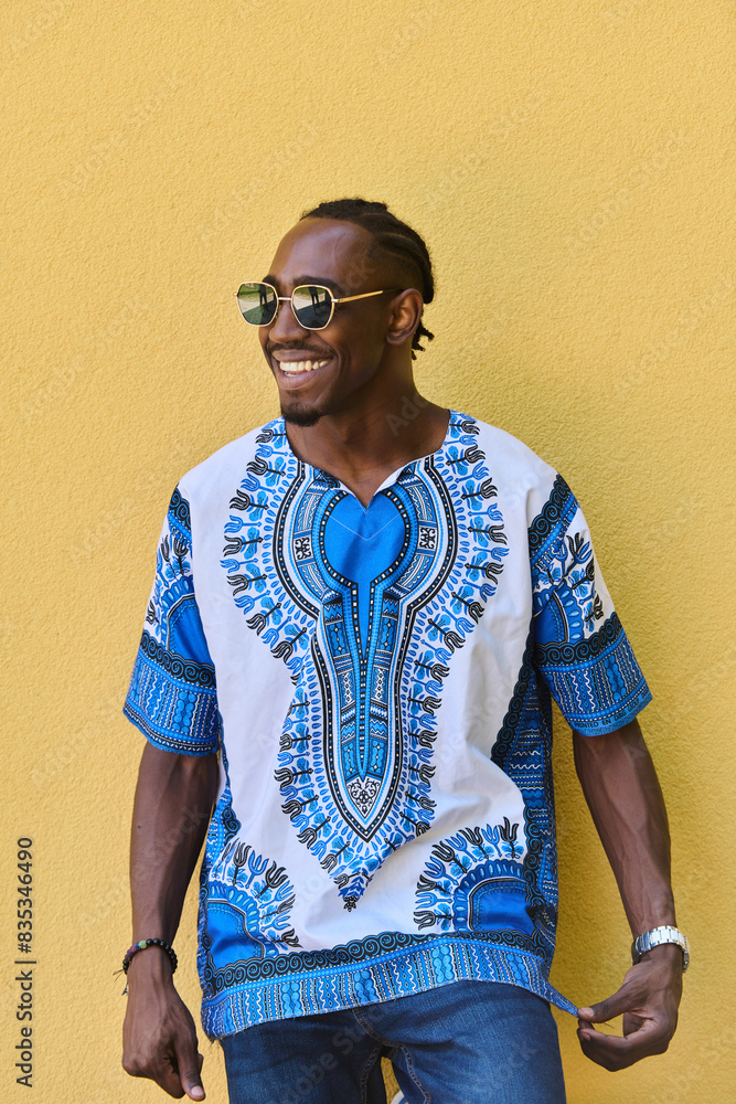 Sudanese Tradition Meets Modern Youth: African American Teen in Vibrant Traditional Attire Against a Yellow Backdrop Sudanese Tradition Meets Modern Youth: African American Teen in Vibrant Traditional Attire Against a Yellow Backdrop