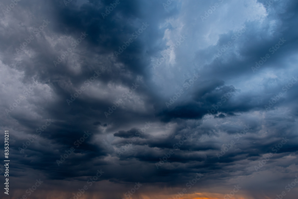 Fototapeta premium A captivating view of dark, swirling storm clouds filling the sky, creating a dramatic and moody atmosphere. The interplay of light and shadow highlights the intensity of the impending weather.