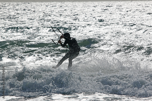 Kitesurfer riding his board in waves