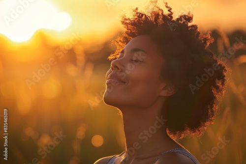 A side profile of a woman against a beautifully lit sky, portraying peace and contemplation at sunset