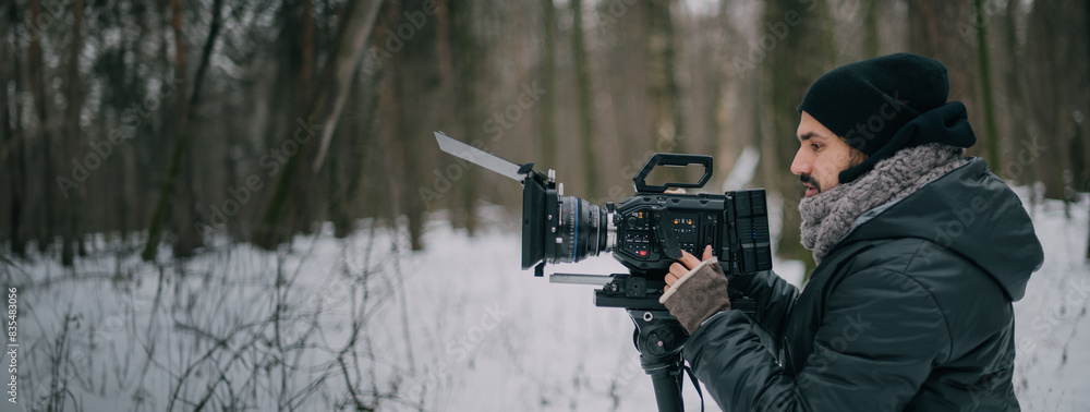 Fototapeta premium Director of photography with a camera in his hands on the set. Professional videographer at work on filming a movie, commercial or TV series