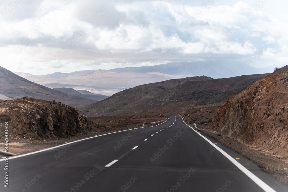 Mountain road on colourful remote basal hills and mountains of Massif of Betancuria, Fuerteventura, Canary islands, Spain Mountain road on colourful remote basal hills and mountains of Massif of Betancuria, Fuerteventura, Canary islands, Spain