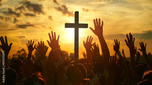 Christian worshipers raising hands up in the air in front of the cross.