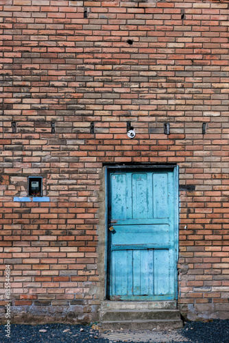 The old blue wooden door in a brick wall of a building in the town of Arcabuco, in the eastern Andean mountains of central Colombia.