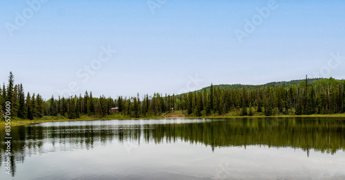 Reflections on lake that is surrounded by mountains and spruce trees. © restlesskath