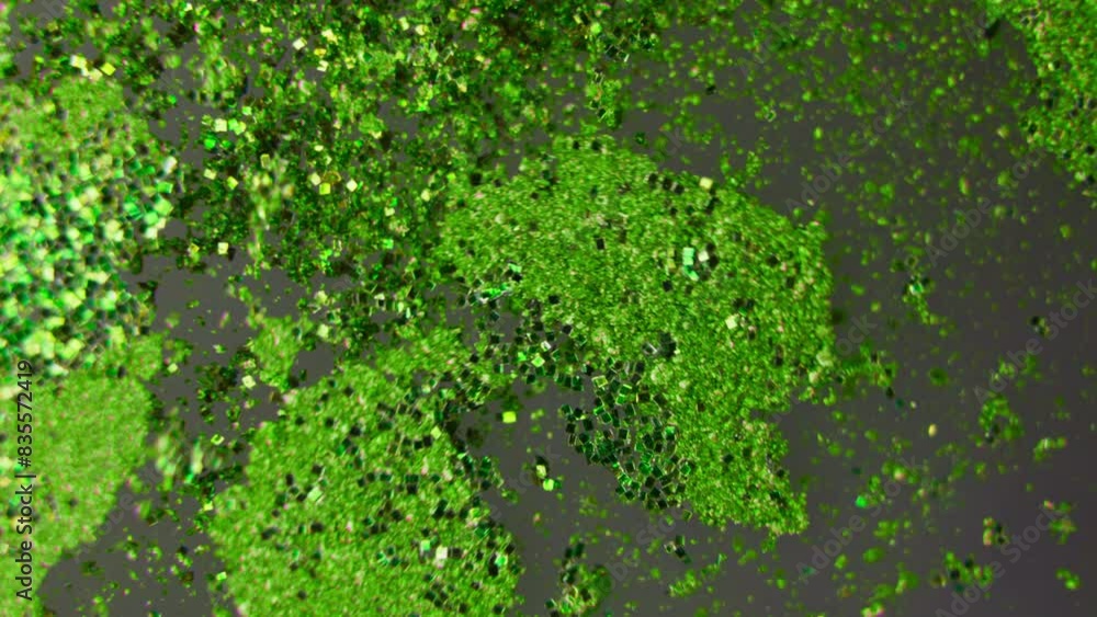 Green particles in a colorful liquid. Green particles in a colorful liquid.