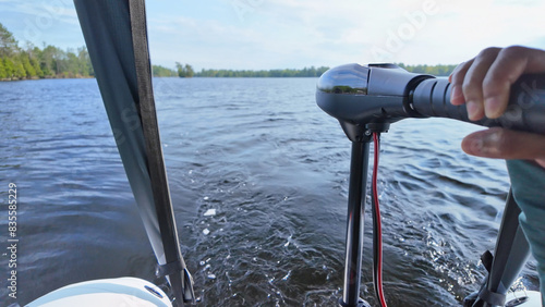 Close up of trolling electric motor at inflatable boat while boating at the lake. Leisure activity of travelling by boat and recreational use of boat vessel. Sports activities fishing and exploring.