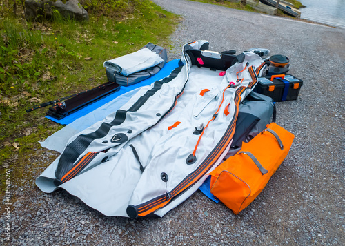 фотографія Deflated Boat catamaran pvc dinghy or rowboat pontoon with electric trolling motor and lithium battery fishing preparation