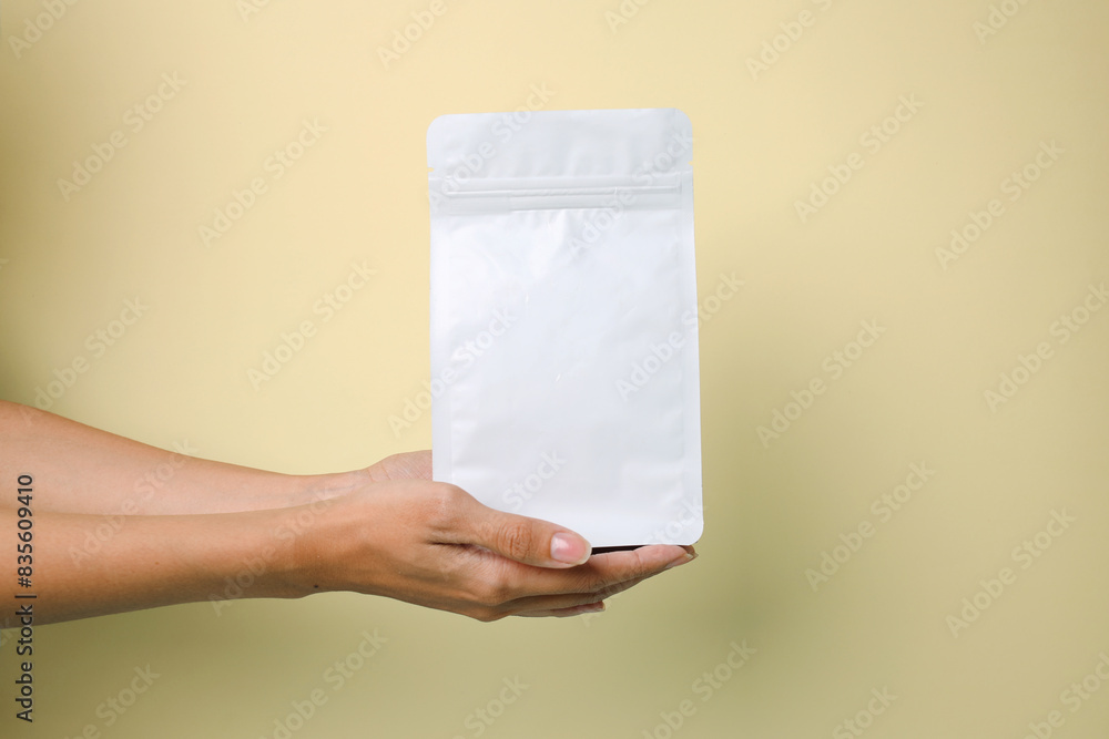Hand Showing Blank White Food Packaging For Mockup Isolated On Yellow Background Hand Showing Blank White Food Packaging For Mockup Isolated On Yellow Background