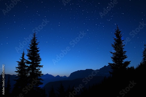 A dark sky with two trees in the foreground and mountains in the background