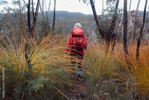 Female hiker walking through thick scrub in the mountains of Australia