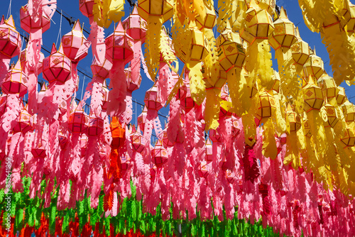 Colorful lanterns under blue sky in Thailand during Loy Krathong festival.