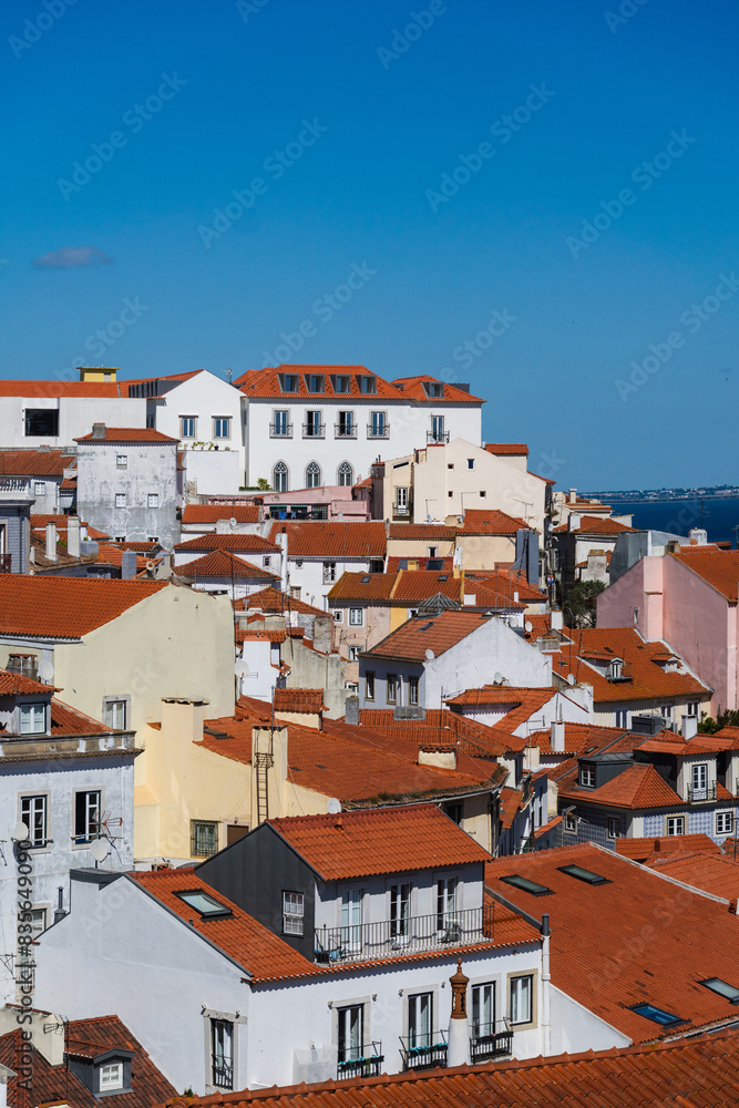 View of the beautiful skyline of Lisbon, Portugal, with red roofed, colorful houses in the Alfama district during a sunny day View of the beautiful skyline of Lisbon, Portugal, with red roofed, colorful houses in the Alfama district during a sunny day