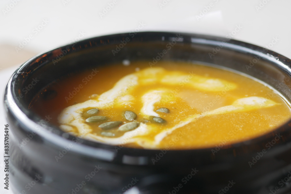 Delicious pumpkin soup in bowl on wooden table, Delicious pumpkin soup in bowl on wooden table,