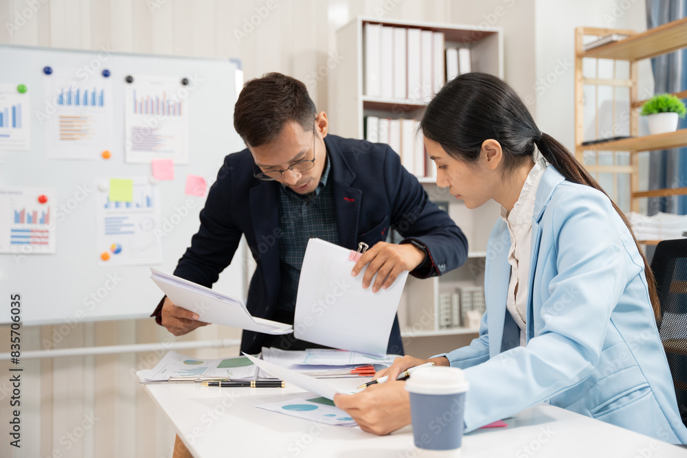 Fototapeta premium Asian business group discussing graph work at the office
