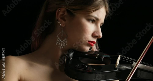 Electric violin sounds, pink-haired artist concentrates