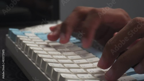 hands typing on wireless keyboard on desk