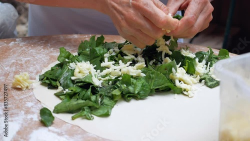 Person preparing spinach and cheese filling for pastry, cooking homemade vegetarian meal photo