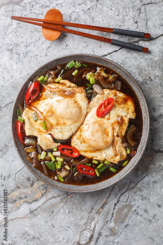 Malaysian simple food soy sauce eggs telur masak kicap closeup on the plate on the table. Vertical top view from above photo