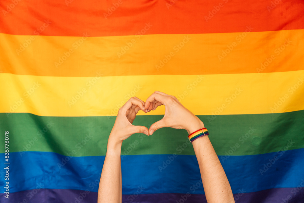 Fototapeta premium Hands showing heart and love against LGBT flag.