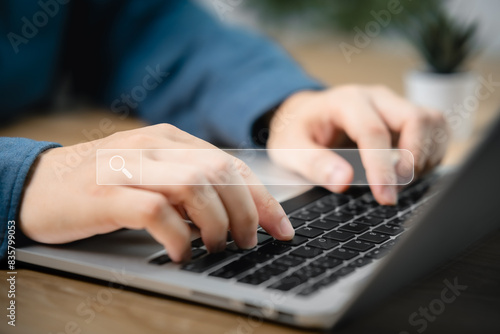Hand of businessman working with computer laptop on desk in office. Search Engine Optimization SEO Networking Concept. Searching Browsing Internet Data Information with blank search bar.