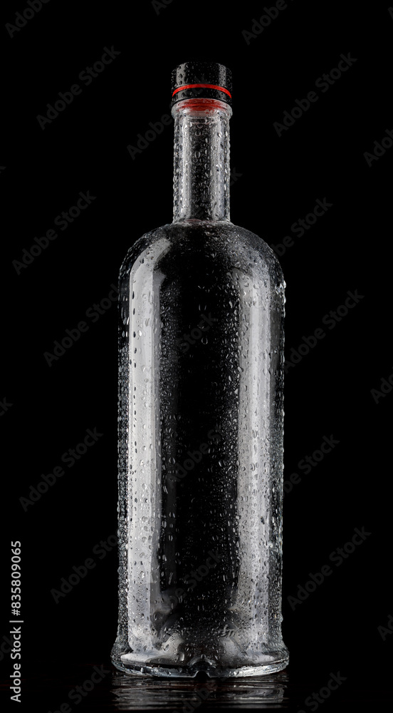 Empty wet glass bottle on a dark background. Empty wet glass bottle on a dark background.