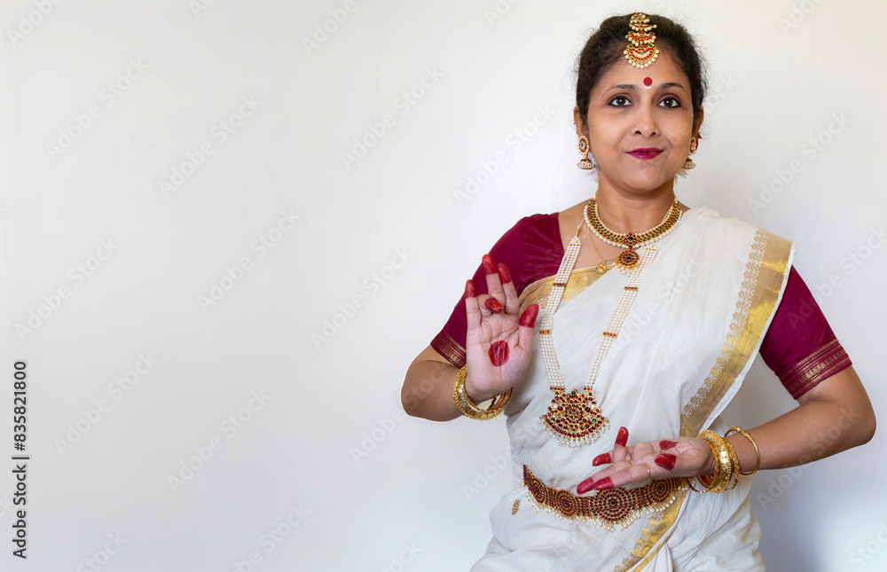 Female Indian classical dancer in Bharatanatyam dance mudra on white background with copy-space. Female Indian classical dancer in Bharatanatyam dance mudra on white background with copy-space.