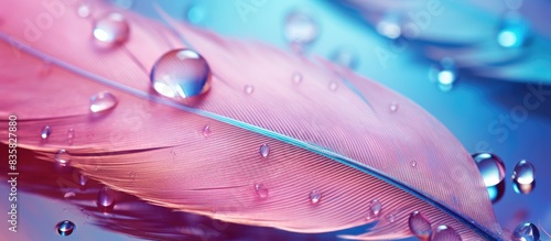Macro shot of a stunning water droplet on a feather, showcasing light blue and pink hues in a soft and delicate setting, perfect for a copy space image.