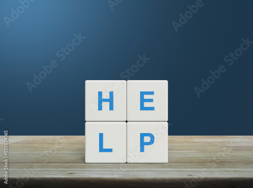 HELP letter on white block cubes on wooden table over light blue wall, Business customer service and support concept