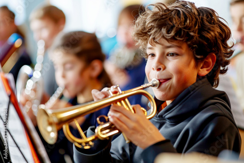 Young boy playing the trumpet in a music class  surrounded by classmates with instruments.