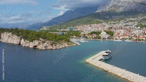
Drone view of tourist town of Makarska, Croatia. Beautiful view of  harbor with boats, yachts, large ships, houses in city, and tmountainous landscape of Biokovo. Summer, sunny day. 