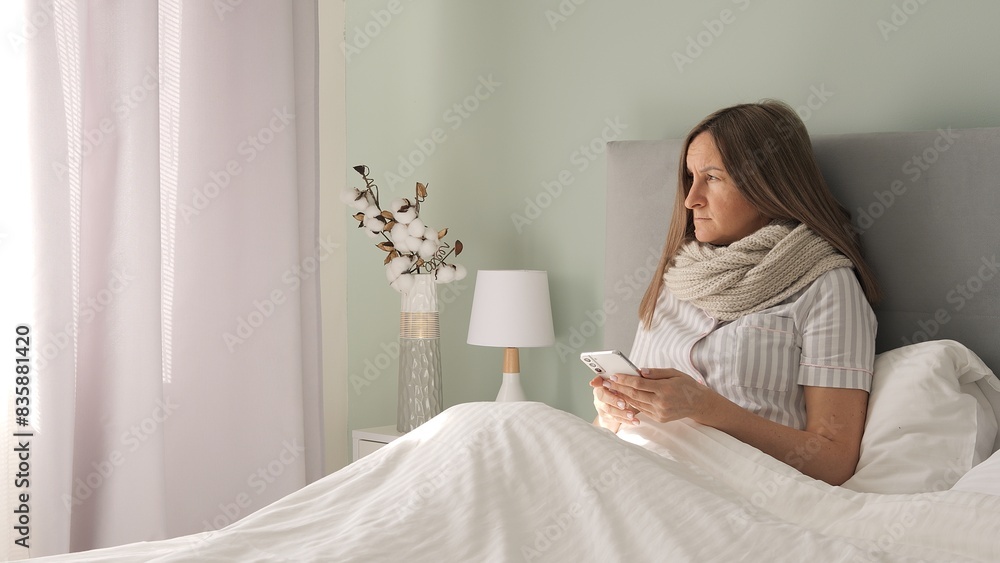 In bed sick drained womans sorrow fills room as she communicates through her phone Sick and weary she finds solace in digital connections amidst gloom of illness seeking comfort in virtual embraces In bed sick drained womans sorrow fills room as she communicates through her phone Sick and weary she finds solace in digital connections amidst gloom of illness seeking comfort in virtual embraces