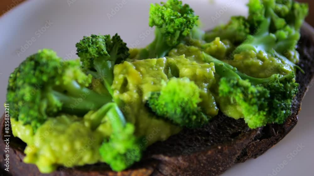 Close-up healthy breakfast toast with thick avocado puree and tender broccoli. Appetizing toast is decorated with greens, creating attractive contrast colors Toast is ideal light and healthy breakfast Close-up healthy breakfast toast with thick avocado puree and tender broccoli. Appetizing toast is decorated with greens, creating attractive contrast colors Toast is ideal light and healthy breakfast