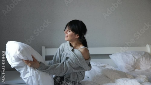 people and bedtime concept - happy young woman in pajama hugging pillow photo