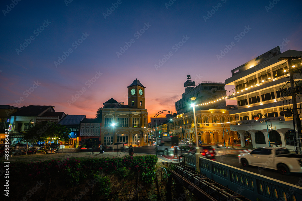 Fototapeta premium Tourists like to take photos at the clock tower, an old building in Phuket city. beautiful sky in twilight.popular landmark in Phuket. a beautiful old building in the heart of Phuket Town.