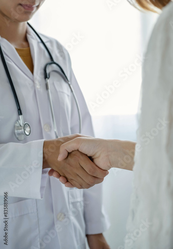 doctor and patient shake hands in the hospital after finishing treatment. health care concept