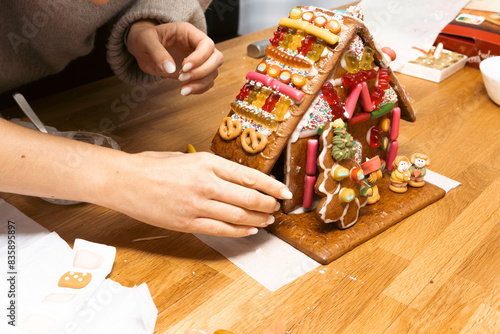 Hands designing gingerbread cookies house. Christmas concept
