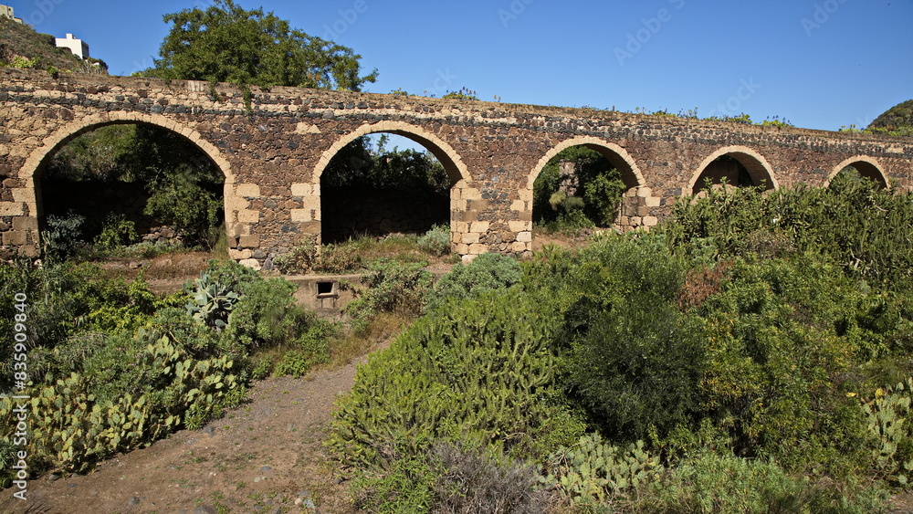 Stone aqueduct at botanical garden Jardin Botanico Canario Viera y Clavijo on Gran Canaria,Canary Islands,Spain,Europe
