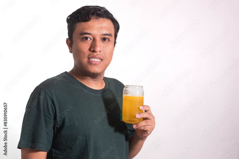 Asian adult man holding a glass of orange juice isolated on white background Asian adult man holding a glass of orange juice isolated on white background