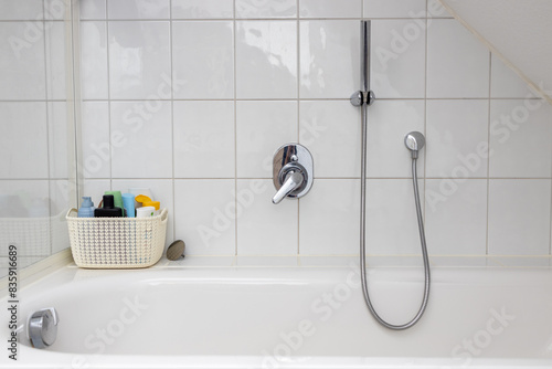Bathtub with the woven basket for shampoo and hair care products