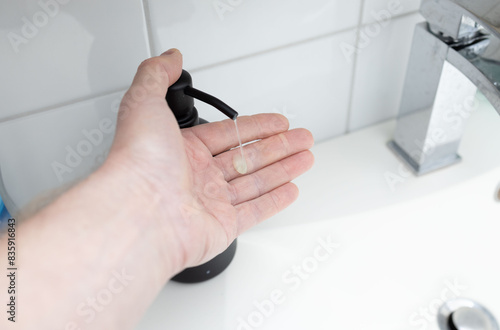 A hand operated soap dispenser in the bathroom